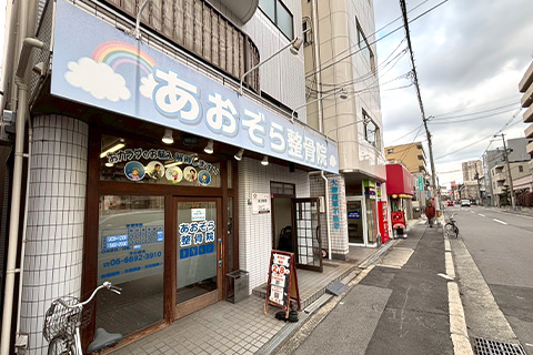 そのまままっすぐ歩くとすぐ左手にたこ焼き屋さん、民家がありその隣があおぞら整骨院です。